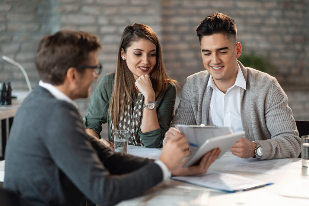 happy couple going through their investment plans with financial advisor.